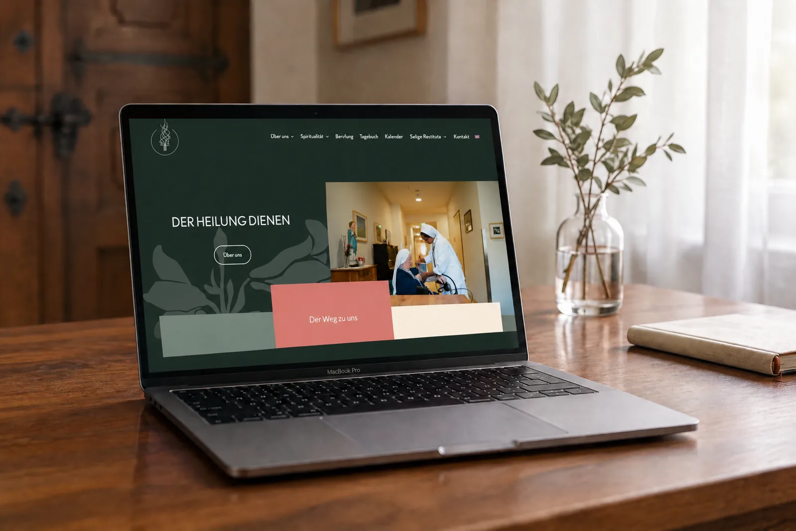 Website der Franziskanerinnen auf einem MacBook in einem ruhigen Klosterumfeld